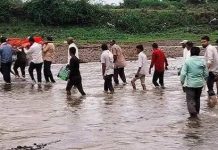 मुक्तिधाम तक पहुंचने के लिए उफनती नदी पार करने को मजबूर ग्रामीण